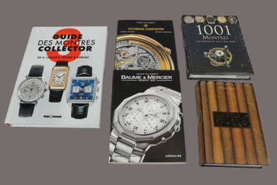 several books and a watch are sitting on a table