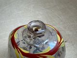 a glass jar with a red and yellow design on it