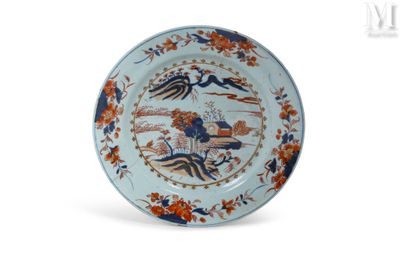 une assiette bleue et orange ornée d'un motif représentant un oiseau