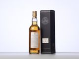 a bottle of whisky sitting next to a box on top of a table