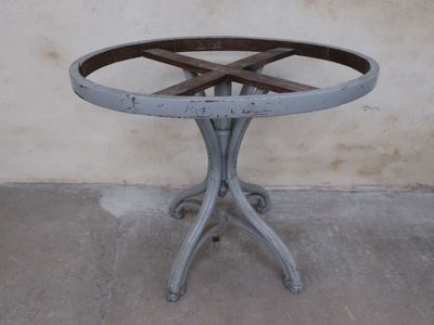 a small table with a wooden top on a cement floor
