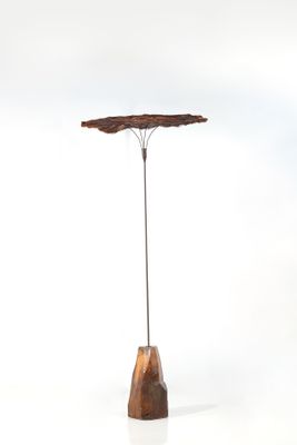 sculpture représentant un arbre, posée sur un socle en bois, sur fond blanc