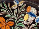 a close up of a decorative plate with flowers on it