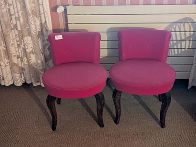 deux chaises roses placées l'une à côté de l'autre dans une pièce