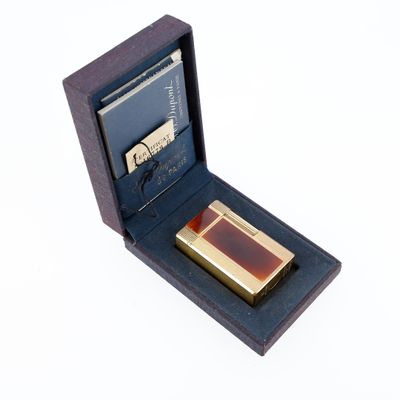 une petite boîte contenant un briquet, posée sur une surface blanche