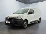 La camionnette blanche est garée dans une grande pièce au sol noir.