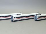 deux trains miniatures posés côte à côte sur une surface grise