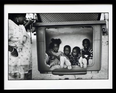 une photo en noir et blanc d'un groupe d'enfants assis devant un téléviseur