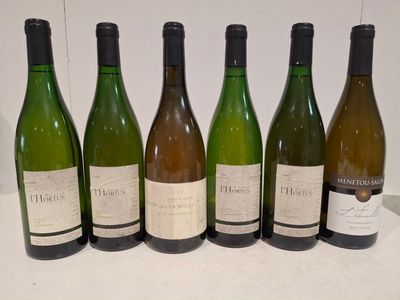 six bouteilles de vin sont alignées sur une table