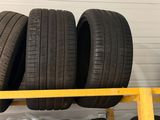 trois pneus sont empilés sur une étagère dans un garage