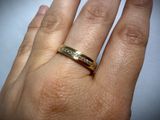a woman ' s hand with a gold ring on it