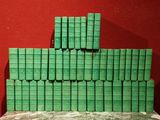 des livres empilés les uns sur les autres sur une table devant un mur rouge