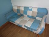 un canapé bleu et blanc dans une pièce avec du parquet