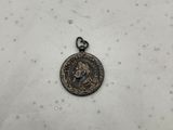 une vieille pièce de monnaie repose sur une surface blanche