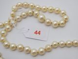 un gros plan sur un collier de perles blanches muni d'une étiquette