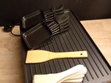 an image of a grill with a spatula and utensils on it