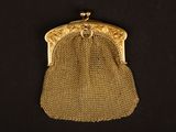 un sac à main en maille dorée à l'ancienne sur fond noir