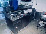 un plan de travail noir dans une cuisine, sur lequel est suspendue une serviette bleue