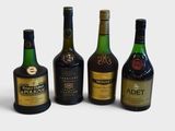four bottles of alcohol are lined up in a row on a white surface