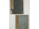 two old books with chinese writing on them sitting on a table