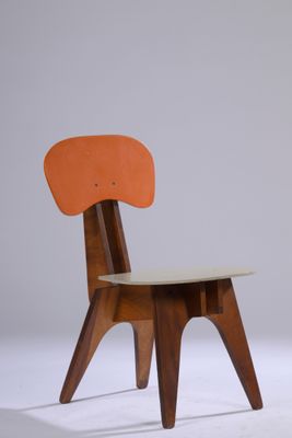 une image représentant une chaise en bois avec une assise orange posée sur une surface blanche
