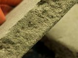 a person holding a piece of cement in their hand