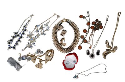 many different types of jewelry on display on a white surface