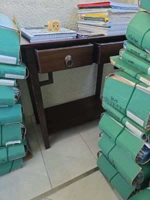 une pile de bagages posée par terre à côté d'un bureau