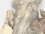 a statue of a woman sitting on a pile of rocks