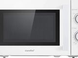 Le micro-ondes est blanc et comporte des boutons sur le côté de la porte.