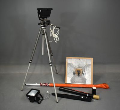 a tripod with a camera and other items on the floor