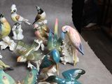 many figurines of birds that are sitting on a table