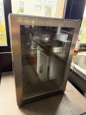 a small refrigerator that is sitting on a counter in a kitchen