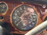 a close up of a car dashboard with a speedometer and a steering wheel