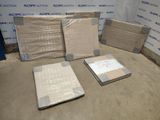 Plusieurs cartons contenant des matelas sont posés par terre devant un mur.