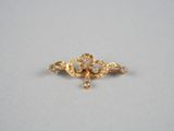 un gros plan sur une broche en or sertie de diamants
