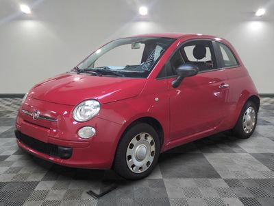 une photo d'une petite voiture rouge garée sur un sol à damier
