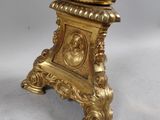 a gold colored telephone on a stand with a cord