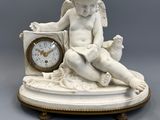 a small statue of a child sitting on a clock