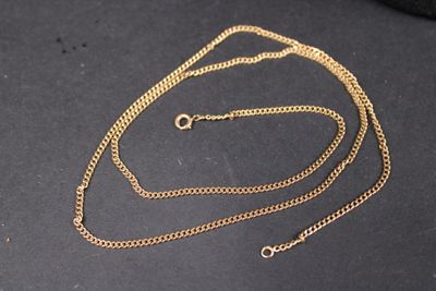a close up of a gold chain on a black surface
