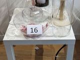 une petite table sur laquelle se trouvent un vase et une bougie