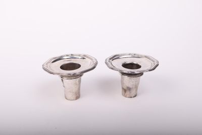 une paire de bougeoirs plaqués argent sur fond blanc