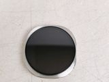 a picture of a round black button on a wall