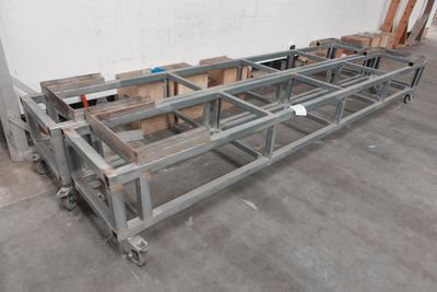 une grande table métallique à roulettes au milieu d'une pièce