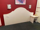 a picture of a bedroom with a red wall and a white headboard
