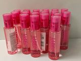 several bottles of pink liquid are lined up on a white surface