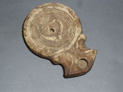 un petit morceau de poterie orné d'un motif circulaire