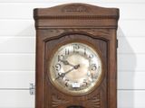 a wooden clock that is hanging on the wall