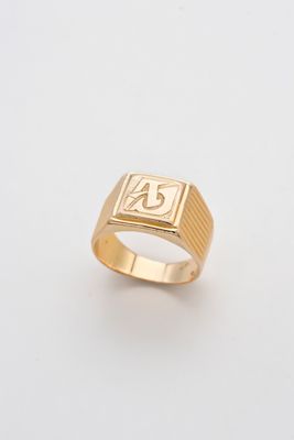 gros plan d'une bague en or sur une surface blanche