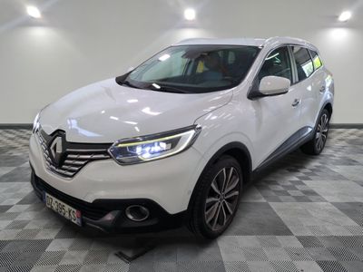 la voiture blanche est garée sur un sol en damier dans le garage